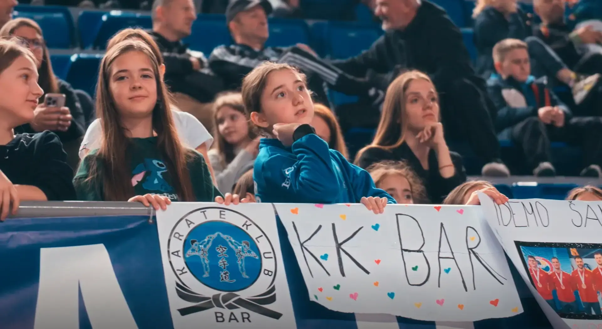 Mlade navijačice na tribinama drže transparent KK Bar.