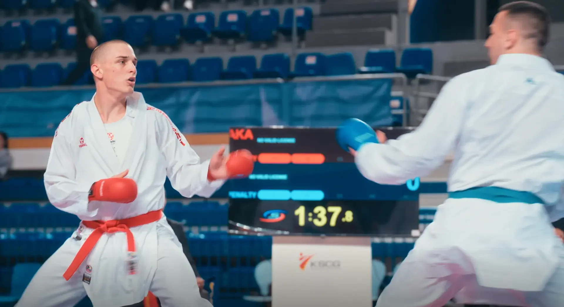 Dva sportista u kimonima i zaštitnim rukavicama tokom borbe.