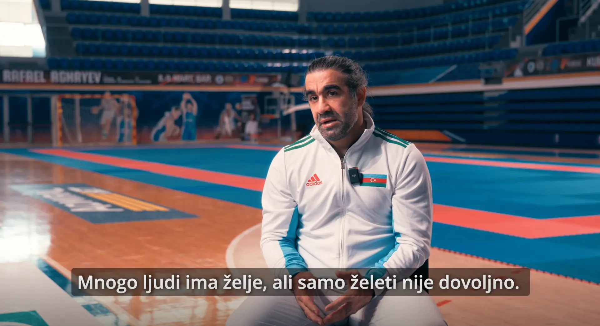 Rafael Agajev tokom intervjua u dvorani, s vidljivim titlom iz filma.