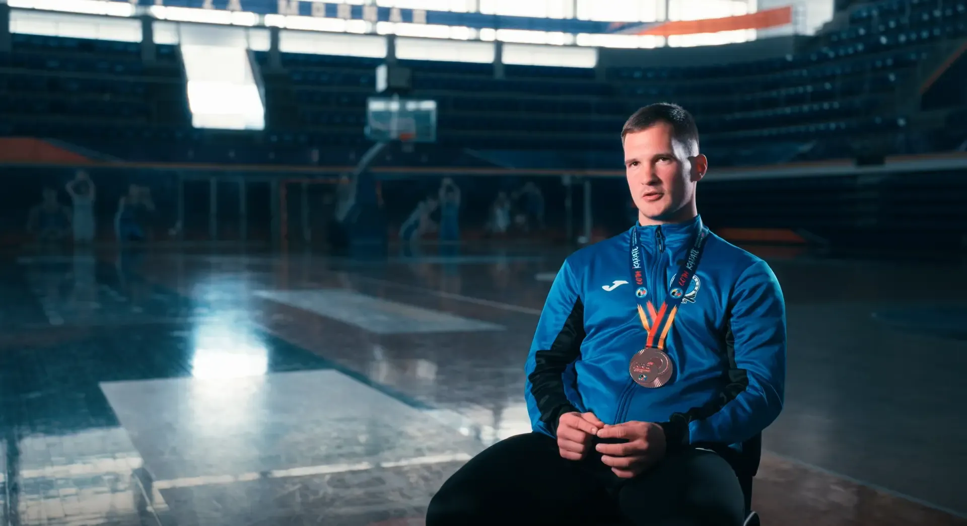 Sportista s medaljom tokom intervjua u dvorani.
